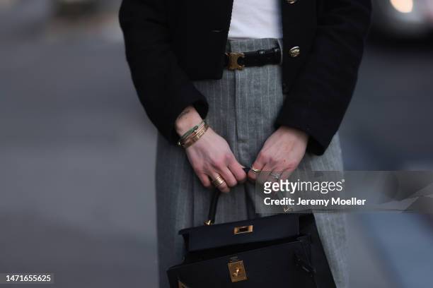 Patricia Wirschke seen wearing Hermès Kelly black leather bag, Loewe white logo top, Rossi grey striped wide leg pants, Celine black leather Triomphe...