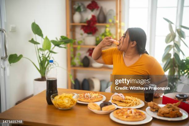 i saw an asian fat girl munching on junk food at the table while she was hungry - chunky chips stock pictures, royalty-free photos & images