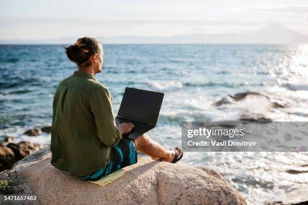 young digital nomad man working by the sea - expatriate stock pictures, royalty-free photos & images