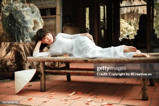 beautiful young lady with conical hat in ao dai dress - asian style conical hat fotografías e imágenes de stock