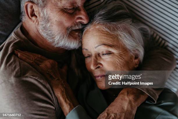 high angle view of senior couple in love,  lying in a bed. - couple and kiss and bedroom - fotografias e filmes do acervo