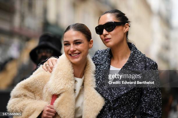 Guest wears a white matte short dress with embroidered silver and yellow stones pattern, a beige sheep long coat, a red pale shiny leather shoulder...