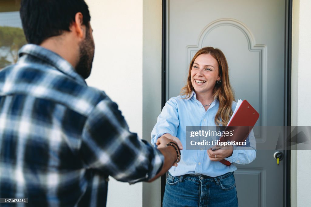 Real estate agent handshake in front of the property entrance