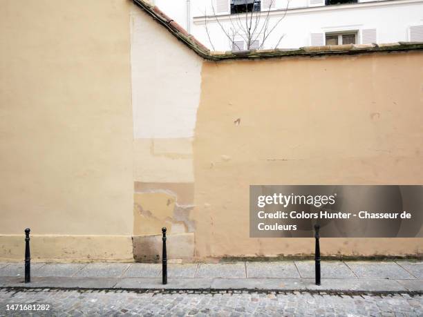empty, painted and weathered wall with building facade in the background and cobbled street in saint-germain-des-pres in paris, france - paris wall stock pictures, royalty-free photos & images