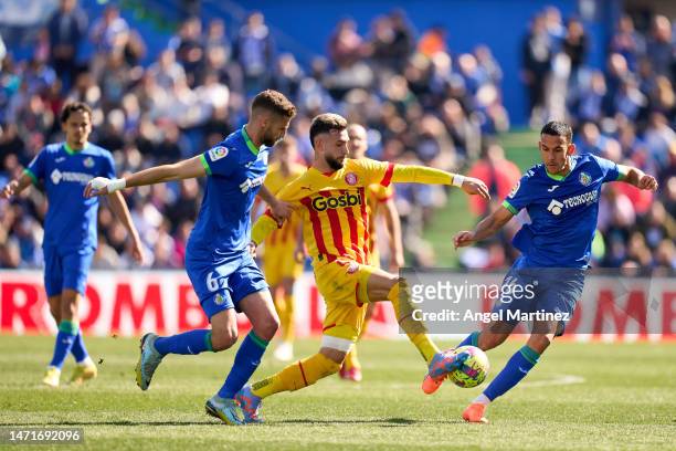 Valentin Castellanos of Girona FC is challenged by Domingos Duarte and Angel Algobia of Getafe CF during the LaLiga Santander match between Getafe CF...