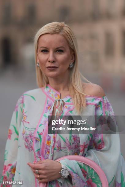 Palina Kozyrava seen wearing Natkina diamond flower earrings and diamond rings, Leonard light blue with pink flower print pattern asymmetrical...