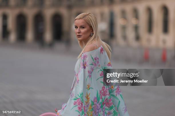 Palina Kozyrava seen wearing Natkina diamond flower earrings and diamond rings, Leonard light blue with pink flower print pattern asymmetrical...