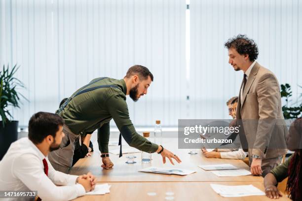 young businessman getting angry at his employees at the office meeting - employee conflict stock pictures, royalty-free photos & images