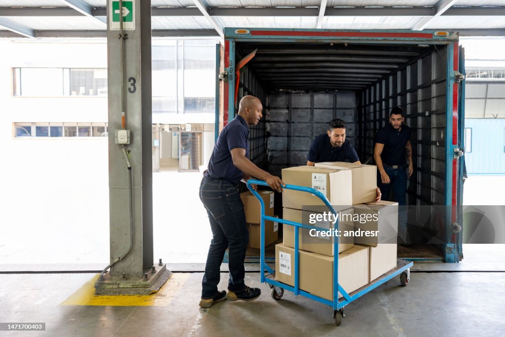 Group of workers loading merchandise on a truck at a distribution warehouse