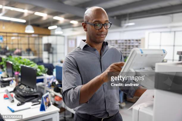 オフィスで働き、文書のコピーを作成するビジネスマン - コンピュータプリンタ ストックフォトと画像
