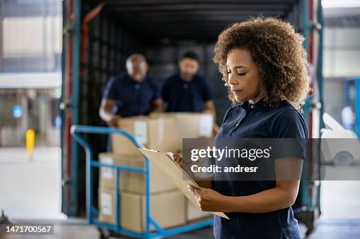 Woman supervising the shipping of cargo at a distribution warehouse Woman supervising the shipping of cargo at a distribution warehouse