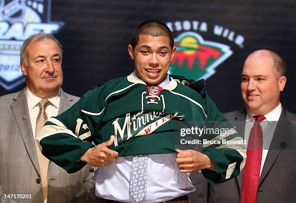 Mathew Dumba, seventh overall pick by the Minnesota Wild, puts on a jersey during Round One of the 2012 NHL Entry Draft at Consol Energy Center on...