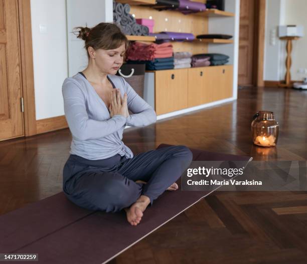 yoga teacher in a greeting pose - tousled hair fotografías e imágenes de stock