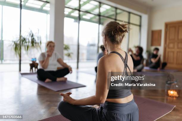 yoga instructor showing breathing exercises or pranayama to a group of mature women breathing exercises or pranayama - pranayama stock pictures, royalty-free photos & images