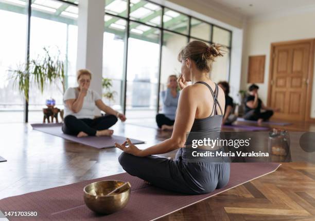 yoga instructor showing breathing exercises or pranayama to a group of mature women breathing exercises or pranayama - pranayama stock pictures, royalty-free photos & images