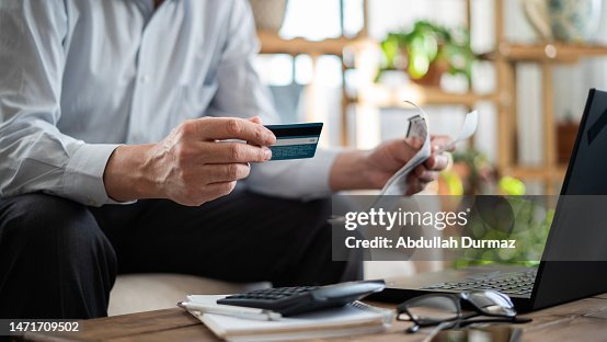 Close-up senior man pays bills with credit card Close-up senior man pays bills with credit card