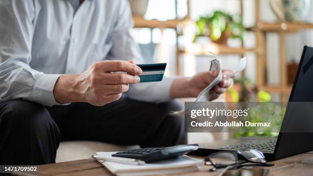 close-up senior man pays bills with credit card - debt 個照片及圖片檔