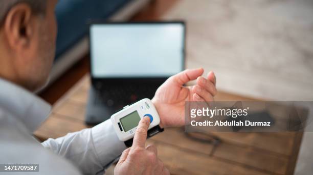 l’homme adulte mesure la pression artérielle avec écran blanc, écran simulé - blood pressure photos et images de collection