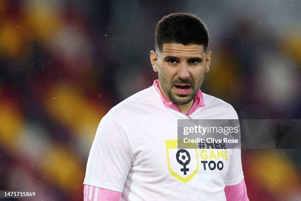 Aleksandar Mitrovic of Fulham looks on wearing a '#HerGameToo' t-shirt as they warm up prior to the Premier League match between Brentford FC and...