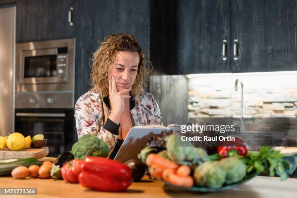 woman holding recipe book, having ideas - reading cookbook stock pictures, royalty-free photos & images