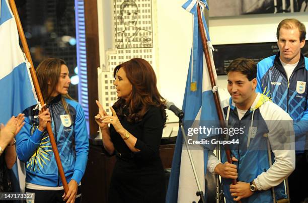 Argentine president Cristina Fernandez de Kirchner talks to the public, while hockey player Luciana Aymar and swimmer Guillermo Marro hold the...