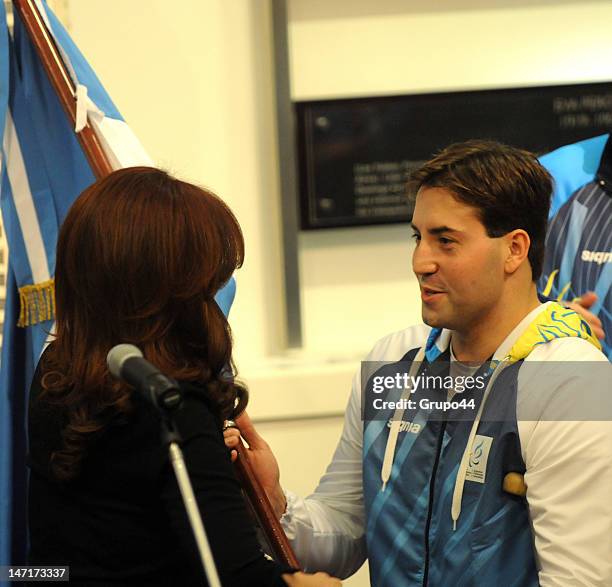 Argentine president Cristina Fernandez de Kirchner gives the national flag to the paralympic swimmer Guillermo Marro during the reception of the...