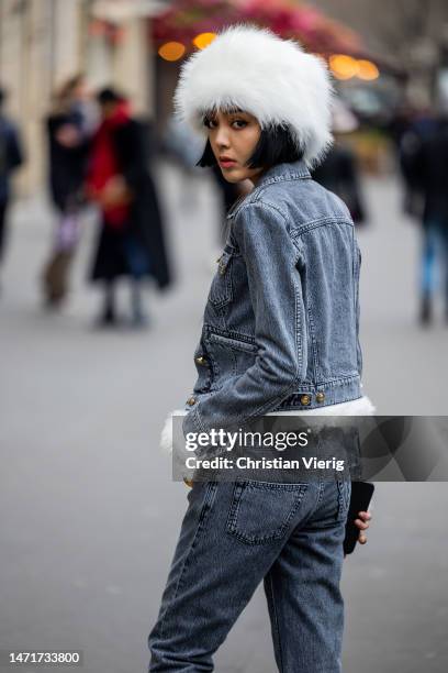 Kiwi Lee Han wears white fur hat, grey denim jacket, jeans outside Palm Angels Paris Fashion Week - Womenswear Fall Winter 2023 2024 : Day Seven on...