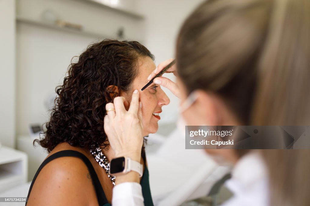 Dermatologe markiert das Gesicht des Patienten vor einem Eingriff