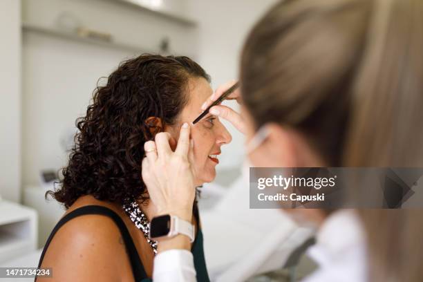 dermatologist marking patient's face before a procedure - dermatologists talking to each other patient stock pictures, royalty-free photos & images