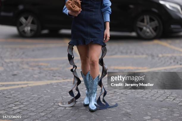 Beatrice Milio seen wearing a denim corsage dress, a blue blouse, blue cowboy boots and a brown bag before the Vivienne Westwood show on March 04,...