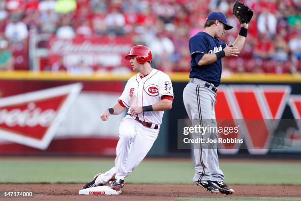 Drew Stubbs of the Cincinnati Reds steals second base in the first inning ahead of the throw to Taylor Green of the Milwaukee Brewers during a game...