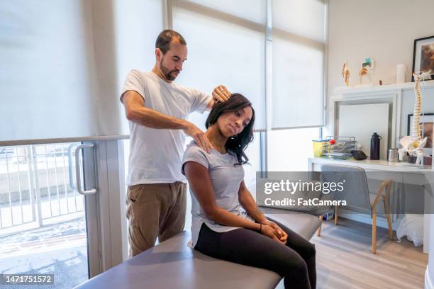 young woman at the chiropractor - osteopathie stockfoto's en -beelden