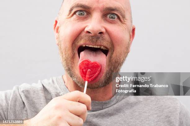 man sucking lollipop - lollipop man stockfoto's en -beelden