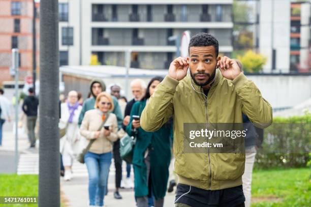 mixed-race man walking on city street - mid adult stockfoto's en -beelden