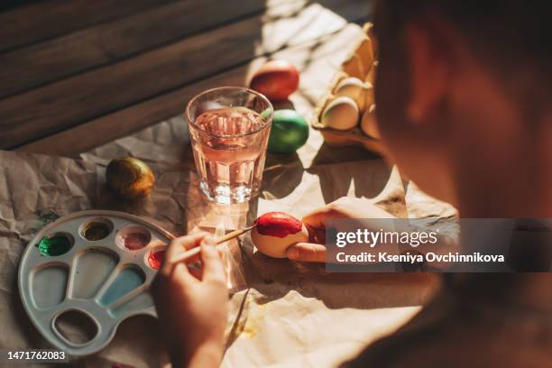 the day before easter, beautiful child painting eggs for easter - chicken decoration stock-fotos und bilder