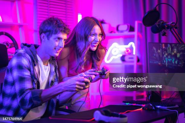influencer gamer couple playing games with joystick live streaming on social media in exciting neon atmosphere , technology concept, recreation - broadcasting room stock pictures, royalty-free photos & images