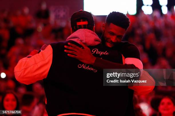 Carmelo Anthony hugs Hakim Warrick during the 20th anniversary celebration of the 2003 national championship during a mens basketball game between...