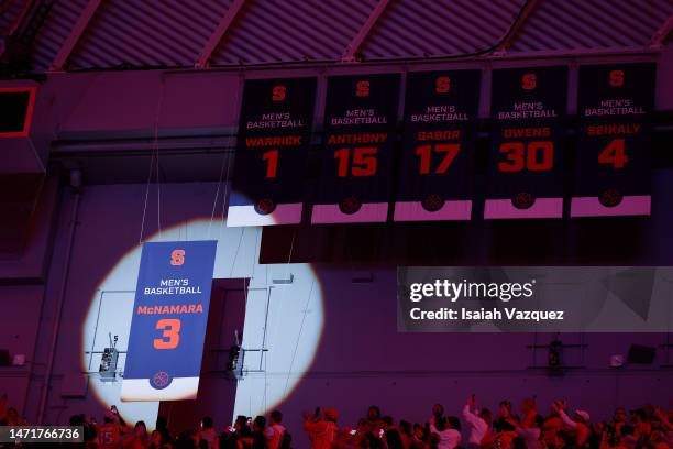 Gerry McNamaras banner is hoisted during the 20th anniversary of the 2003 national championship celebration held during halftime of a mens basketball...