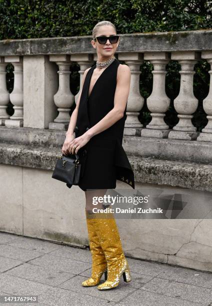 Caroline Daur is seen wearing a black Louis Vuitton dress, gold Louis Vuitton boots and Louis Vuitton bag outside the Louis Vuitton show during Paris...