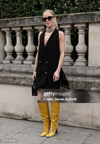 Caroline Daur is seen wearing a black Louis Vuitton dress, gold Louis Vuitton boots and Louis Vuitton bag outside the Louis Vuitton show during Paris...