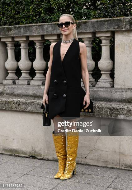 Caroline Daur is seen wearing a black Louis Vuitton dress, gold Louis Vuitton boots and Louis Vuitton bag outside the Louis Vuitton show during Paris...