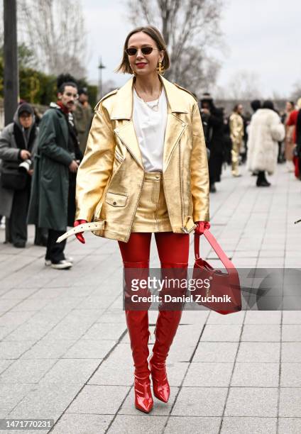 Guest is seen wearing a gold jacket, white shirt, gold skirt, red thigh high boots and red bag outside the Louis Vuitton show during Paris Fashion...