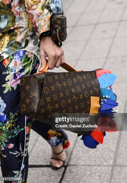 Guest is seen wearing a floral Louis Vuitton jacket and pants with a brown Louis Vuitton bag and red sunglasses with Louis Vuitton gold jewelry...