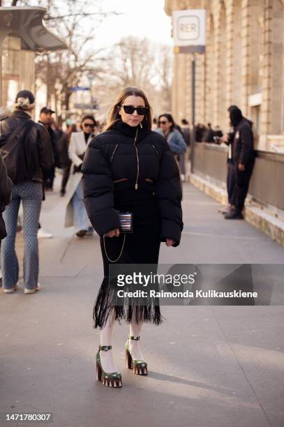 Julia Comil is seen wearing black cropped puffer jacket, black skirt, with tassels, white tights, platform shoes in red, white and green color...