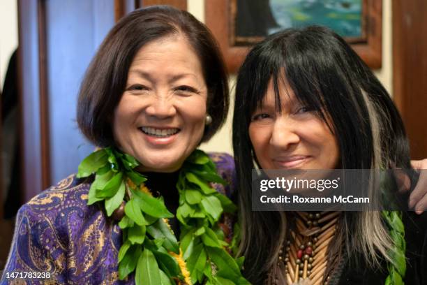 Rep. Mazie Hirono wearing a maile lei poses with supporter of Barack Obama singer-songwriter Buffy Sainte-Marie in her office in January 2009 in...