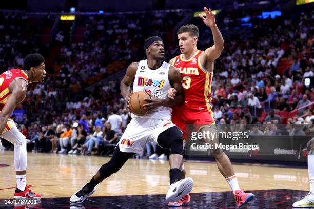 Jimmy Butler of the Miami Heat drives against Bogdan Bogdanovic of the Atlanta Hawks during the third quarter of the game at Miami-Dade Arena on...