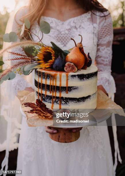 close up of bride holding a wedding cake - serving dish stock pictures, royalty-free photos & images