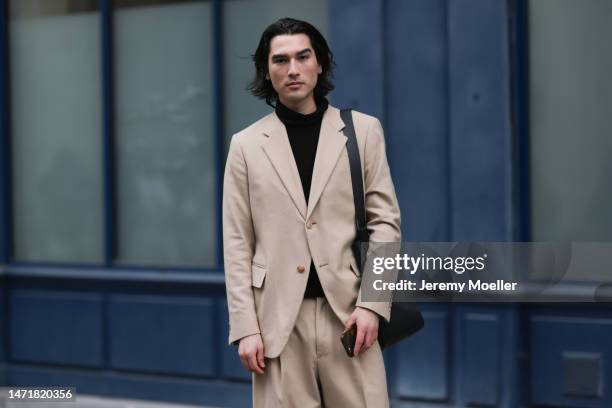 Fashion Week Guest is seen wearing a beige suit, black turtleneck, black handbag and black shoes outside Lanvin show during the Paris Fashion Week -...