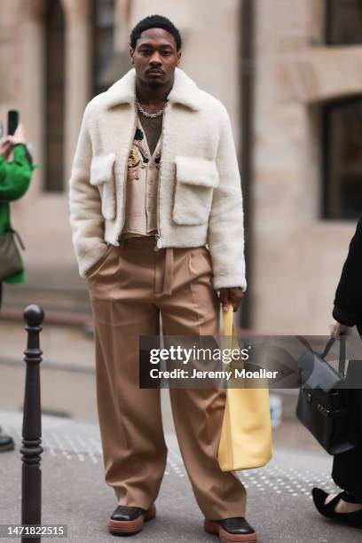 Fashion Week Guest is seen wearing beige brown wide pants, beige vest, brown shoes, beige fur jacket and yellow leather handbag outside Lanvin show...