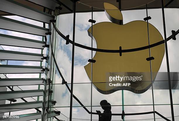 Woman looks at a mobile phone inside an Apple store in Hong Kong on June 27, 2012. Apple on June 27 launched its iTunes Store in 12 Asian markets,...